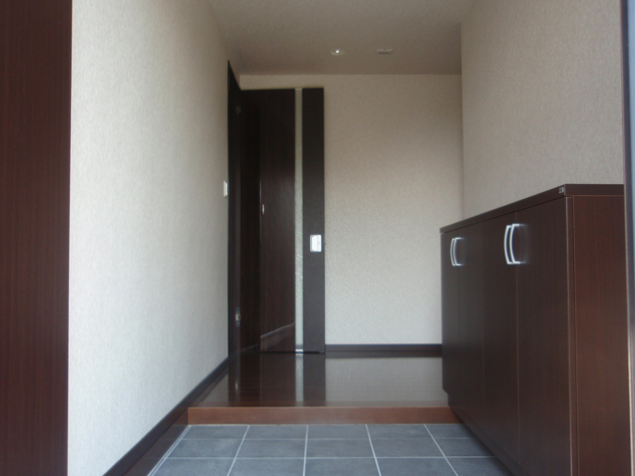 お掃除用具などをしまいたいというご要望で、縦長のロッカー型下駄箱をプラスしました。 実はこの建材シリーズは、リニューアルしてしまって若干色合いが変わってしまったのですが、なるべく近いものを選びました。 違和感が少ないのは鏡の扉を入れたからでしょうか。 ピッタリ収まって良かったぁ